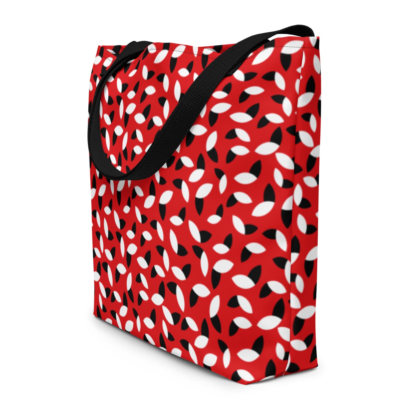 Red tote bag with a bold pattern of alternating black and white petal shapes. Features sturdy black handles, creating a modern and vibrant look.