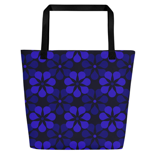A tote bag with black handles features a vibrant, repeating pattern of abstract blue flowers on a dark background, creating a bold and modern look.