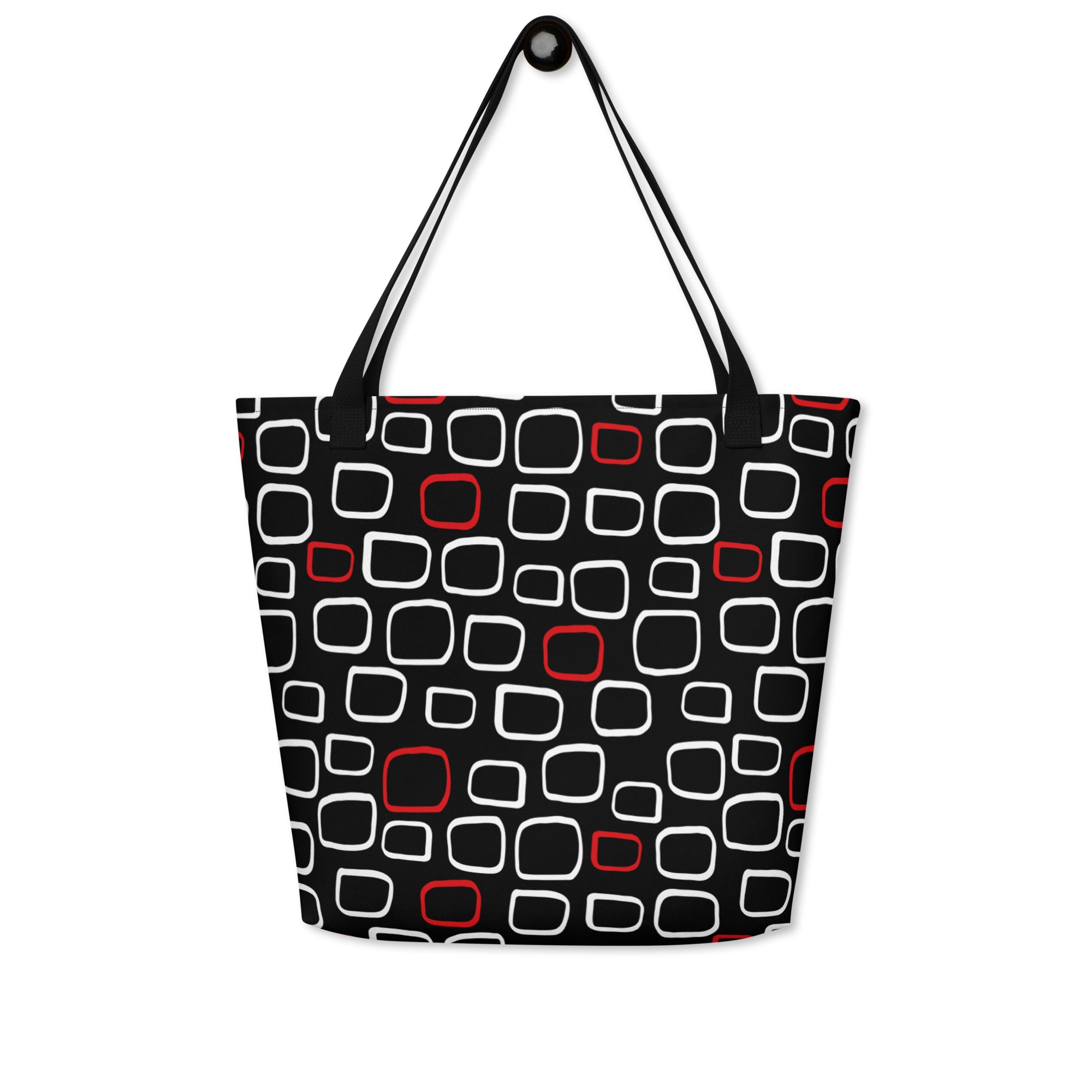 Tote bag with black handles, featuring a black background with red and white outlined geometric squares, creating a modern, playful pattern.