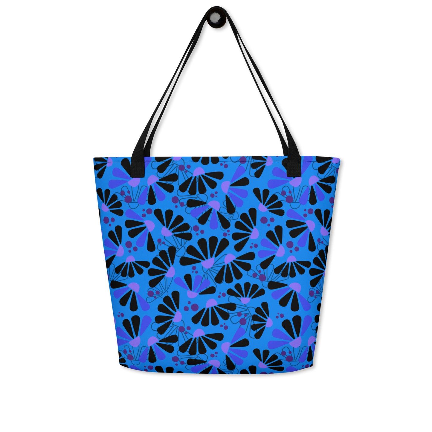 Blue tote bag with black handles, featuring a bold coneflowers pattern of black and purple abstract shapes resembling flowers; a vibrant and modern design.
