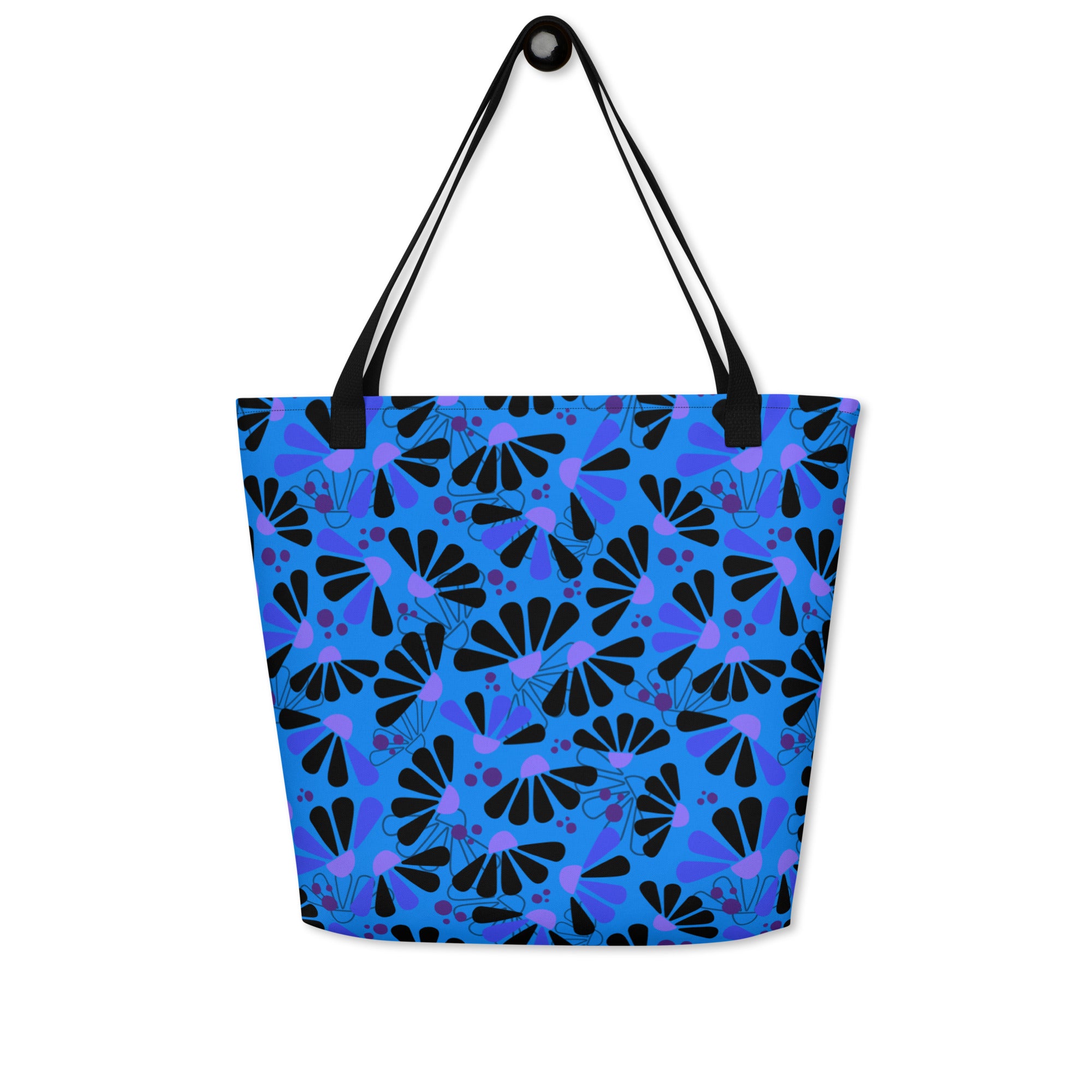 Blue tote bag with black handles, featuring a bold coneflowers pattern of black and purple abstract shapes resembling flowers; a vibrant and modern design.