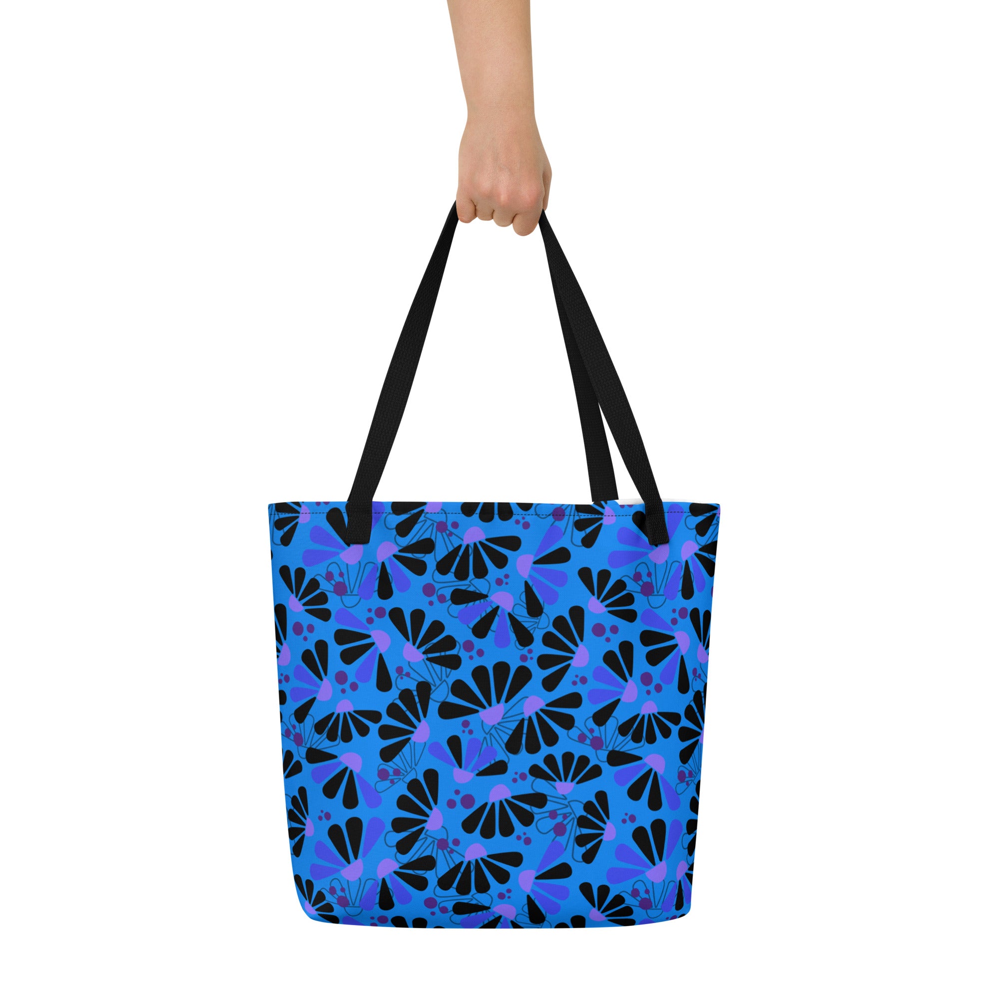 Blue tote bag with black handles, featuring a bold coneflowers pattern of black and purple abstract shapes resembling flowers; a vibrant and modern design.