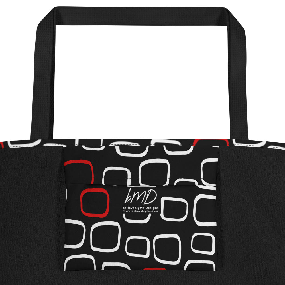 Tote bag with black handles, featuring a black background with red and white outlined geometric squares, creating a modern, playful pattern.