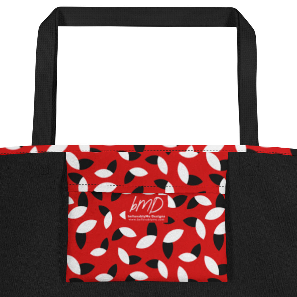 Red tote bag with a bold pattern of alternating black and white petal shapes. Features sturdy black handles, creating a modern and vibrant look.
