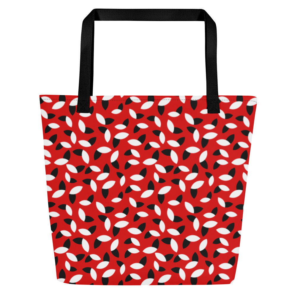 Red tote bag with a bold pattern of alternating black and white petal shapes. Features sturdy black handles, creating a modern and vibrant look.