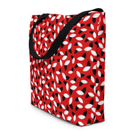 Red tote bag with a bold pattern of alternating black and white petal shapes. Features sturdy black handles, creating a modern and vibrant look.